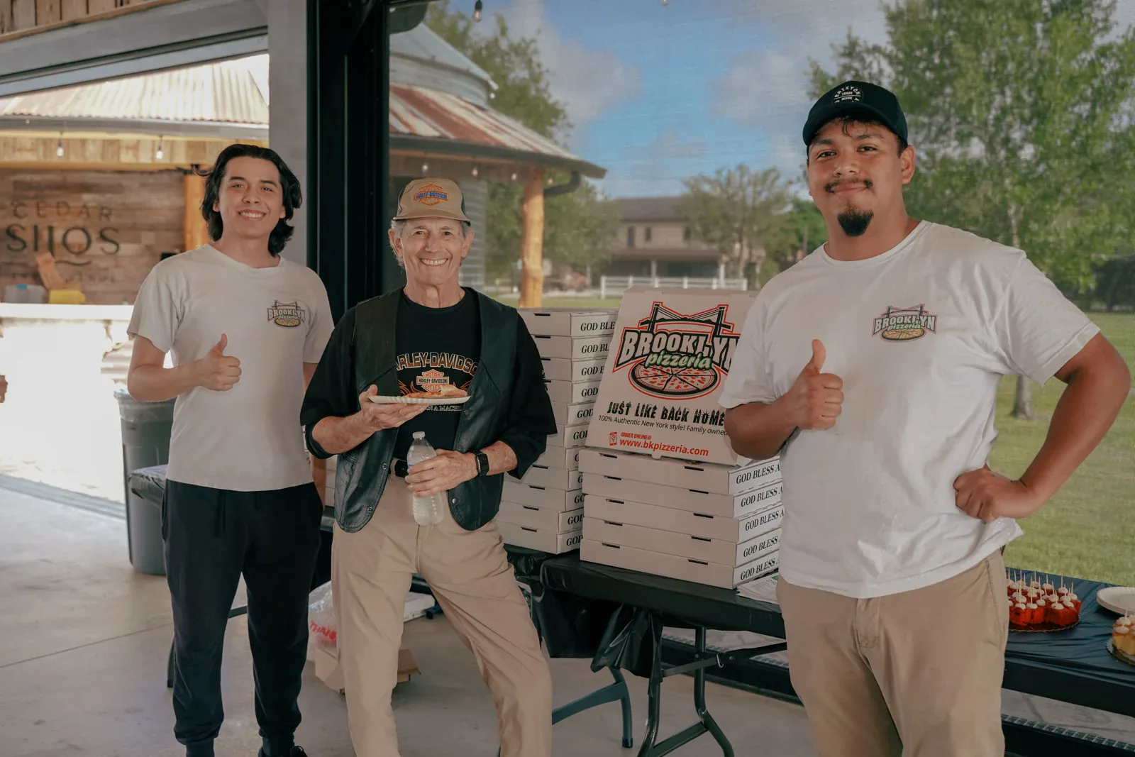 Brooklyn Pizzeria team members with a guest at a community gathering