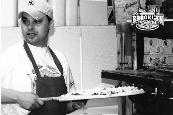 A pizza maker at the oven, from the Brooklyn Pizzeria family archive