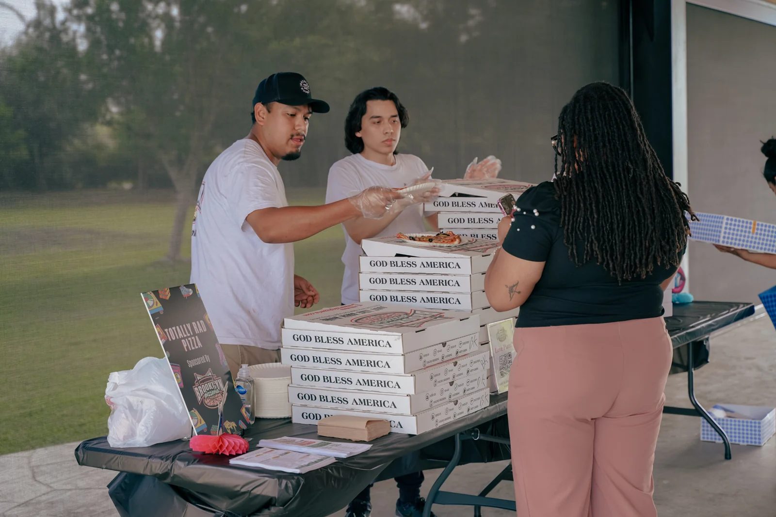 The Brooklyn Pizzeria team serving pizza at a community gathering