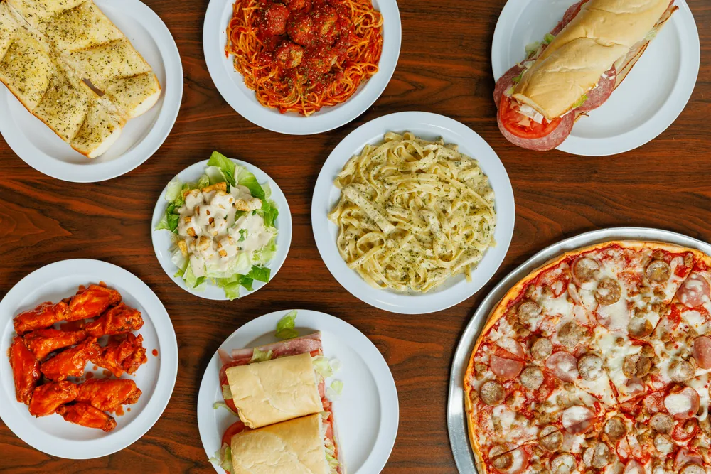 A Brooklyn Pizzeria spread of pasta, wings, sandwiches, salad, garlic bread and pizza